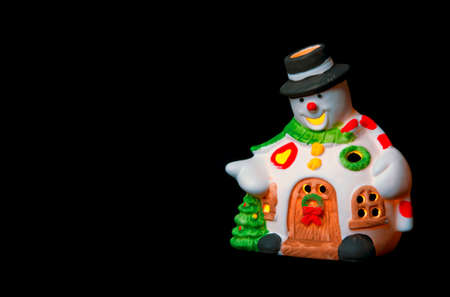 A snowman decorated as a house for a Christmas card purpose, on a black backgroundの写真素材