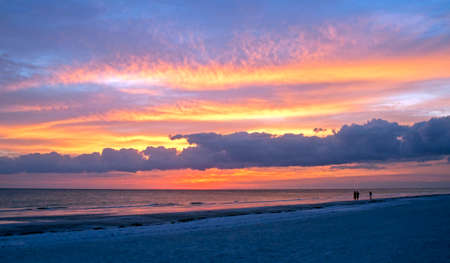 Beautiful cloudy sunset at Siesta Key, with people in silhouette in the foreground.の写真素材