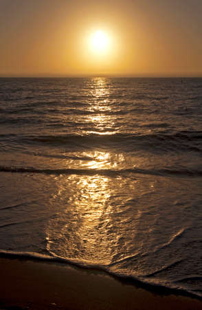 A few small and soft waves over the sand during sunset at Clearwater Beachの写真素材