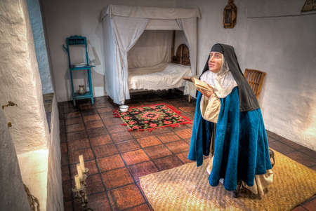 Cuenca, Ecuador, November 2013: Replica of a nuns quarters and how it was centuries ago, with a wax statue of a nun praying, inside a museum.のeditorial素材