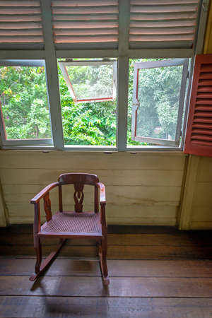 Old 19th century wooden rocking chair in an old replica house, at the Parque Nacional (National Park), in Guayaquil, Ecuador.の写真素材