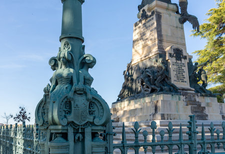 This monument (out of focus) honors CÃ¡ndido LÃ³pez Sanz, the Mesonero Mayor de Castilla. The bronze statue, with its ornate base and historical lamp post, stands in Segoviaの写真素材