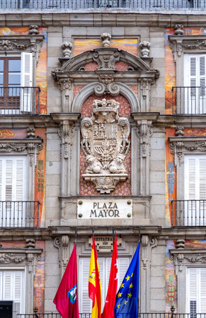 A close-up of the ornate central crest, flags, and name plaque on the frescoed faÃ§ade of Madrid's Casa de la PanaderÃ­a in the Plaza Mayor, featuring Baroque and Hapsburg detailの写真素材
