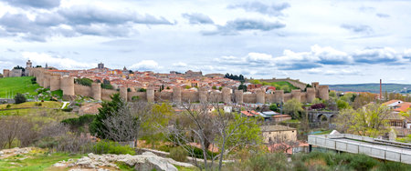 A panoramic lookout view over the magnificent Walls of Ãvila, with numerous stone towers...