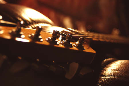 A guitar headstock featuring the tuning posts and string windings.