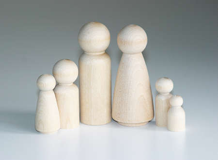 A family of wooden peg people gathered together