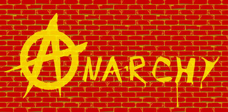 The word anarchy painted onto a red brick wall in yellow paintの写真素材