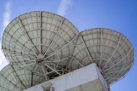 Three satellite dishes on background blue skyの写真素材