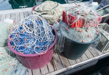 Fishing nets and fishing tackle are on wooden pier