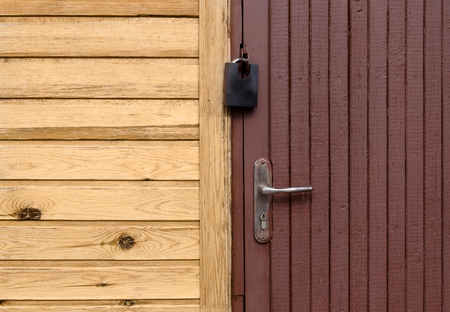 Wooden closed door is in wall of clapboard houseの写真素材