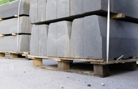 Stack of gray curbstone on pallet standing on pavement.Small depth of fieldの写真素材
