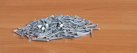 Heap of nails are on wooden surfaceの写真素材