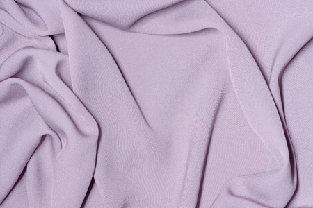 Background made of silk pink cloth. Texture fabric with foldsの写真素材