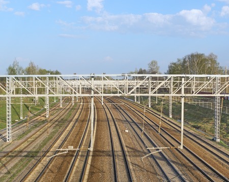 Railroad track converge to horizon and props of power line. Sunny dayの写真素材