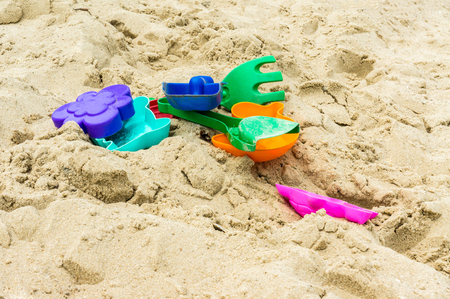 Heap of multicolored plastic toys are on sandの写真素材