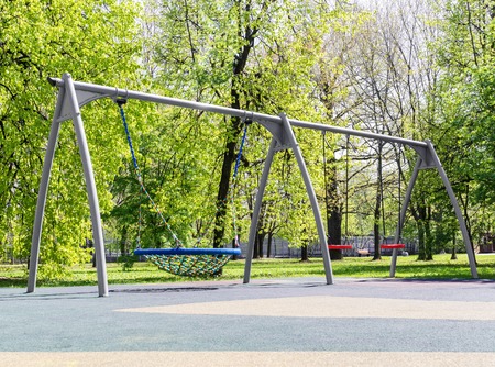 Swing is in park on playground. Area with coating of rubber crumbsの写真素材