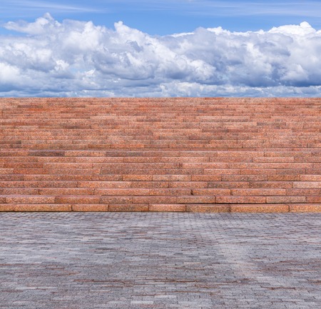 Red granite staircase with pedestals faced stone and sky with cloudsの写真素材