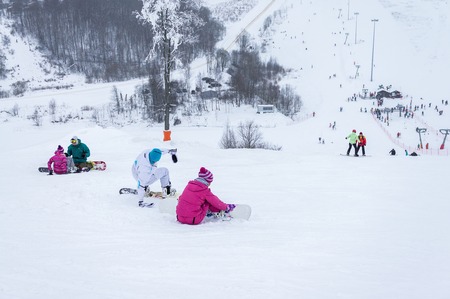 MOSCOW, RUSSIA - JANUARY 25, 2015: Ski club Leonid Tyagachev-oldest ski resort in Moscow region and training base for Russian national teams.Young men and womens on ski slope are fastening snowboardsのeditorial素材