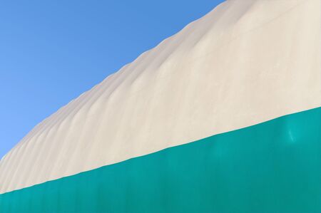 Dome of inflatable hangar against background blue cloudless sky. Copy space