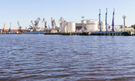 Wharf near tanks of oil loading or liquefied gas terminal in cargo port. Sunny day