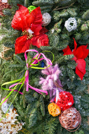 Christmas balls, flowers and ribbons are on spruce branches dusted with snow. Festive backgroundの写真素材