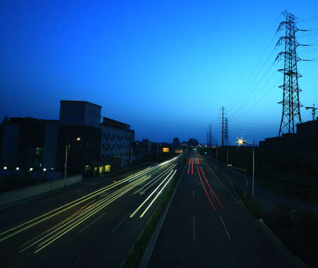 View long exposure of cars passing through of the highway and transmission towerの写真素材