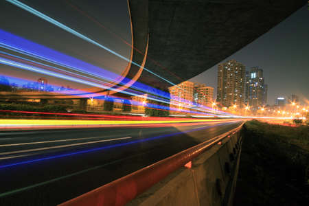 Large urban ring highway viaduct long exposure photo light trails night sceneの写真素材