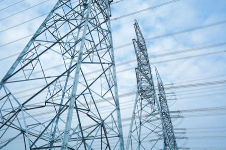 High-voltage power transmission towers in sky backgroundの写真素材