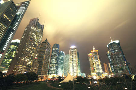 Looking up at the modern office buildings at night in Shanghaiの写真素材