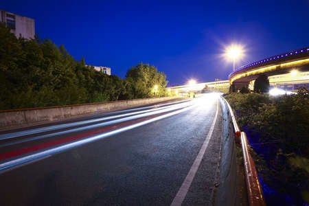 high-speed urban viaduct construction night view car light trailsの写真素材