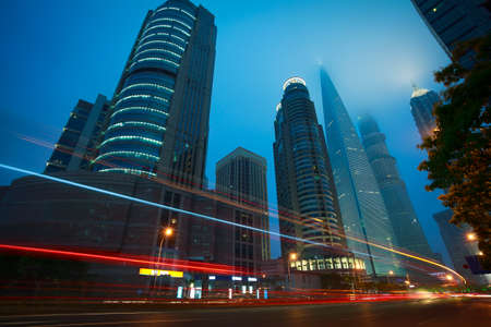 Bottom angle shooting highway car light trails of modern urban buildingsの写真素材