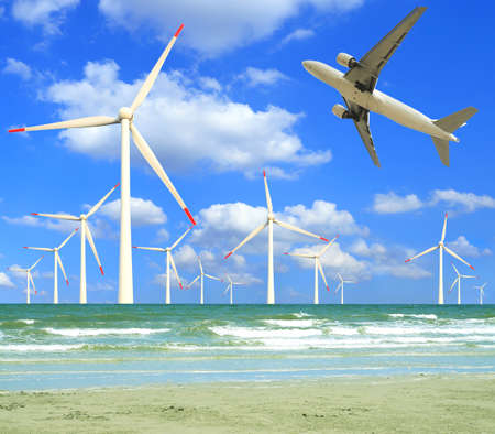 Aircraft is flying in eco power of wind turbines in the sea skyline at concept の写真素材