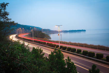 Evening night view  overlooking the lake curved highwayの写真素材