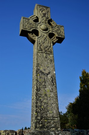 A view of a stone Celtic Cross headstone in a graveyard in the Perthshire town of Blackford near...