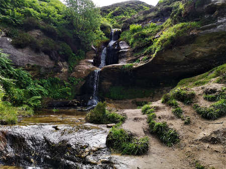 A view of the waterfall cascading over eroded rock in Glen Vale near John Knoxâs pulpit on the slopes of West Lomond hill in Fife, Scotlandの写真素材