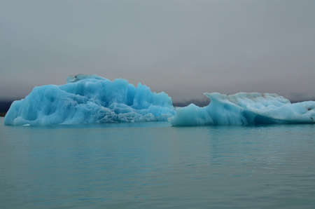 A view of floating iceberg fragments and glaciers in the glacial lagoon in southern Iceland