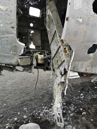 A view of an old crashed military aircraft on a black sand beach in southern Iceland