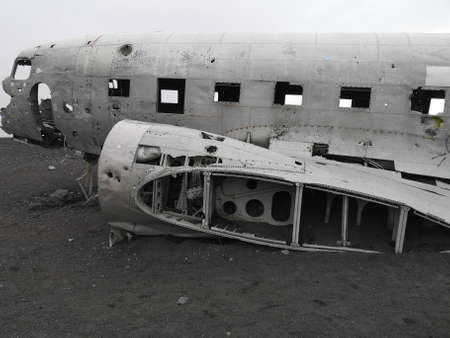 A view of an old crashed military aircraft on a black sand beach in southern Icelandの写真素材