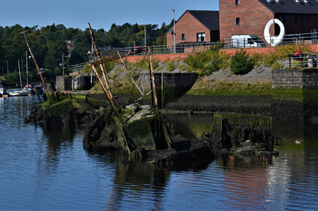 A view of old ruined boats in the old harbor at Dumbarton in Scotlandの写真素材
