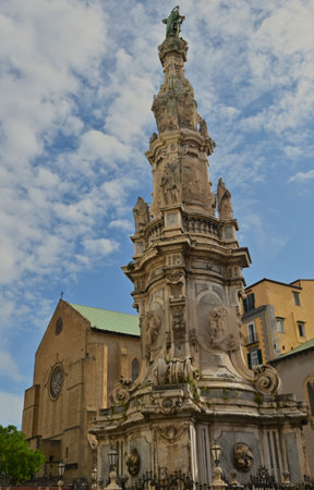 A view of an elaborately decorated stone obelisk in a piazza in the city of Naples in Italy.の写真素材