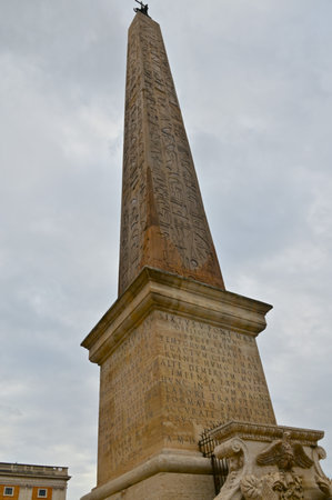 A view of an ornate stone obelisk in a piazza in the city of Rome in Italy.の写真素材