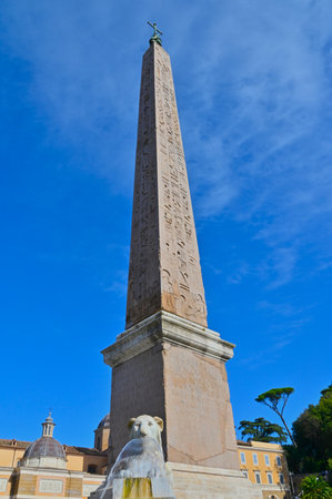 A view of an ornate stone obelisk in a piazza in the city of Rome in Italy.の写真素材
