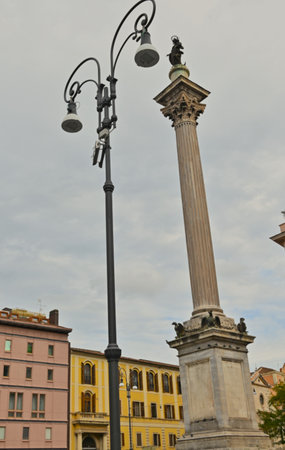 A view of an ornate monumental column in a piazza in the city of Rome in Italy.の写真素材
