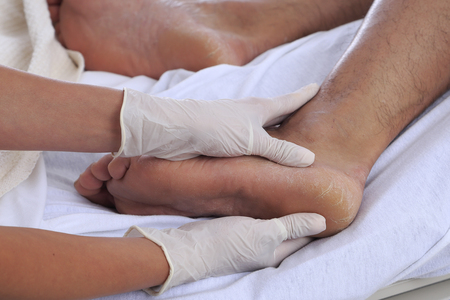 Healthcare environment with caregiver checking patients footの写真素材