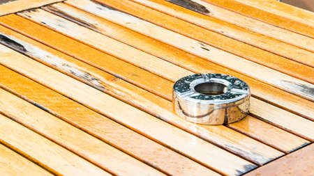 Empty steel ashtray put in a wood tableの写真素材