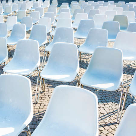 White plastic chairs waiting for audience at an open-air eventの写真素材
