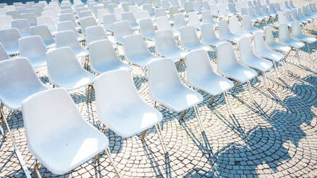 White plastic chairs waiting for audience at an open-air eventの写真素材