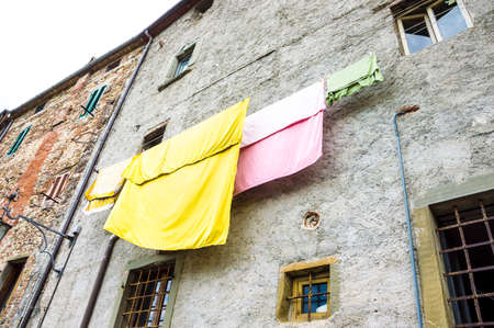Hanging colorful clothes in a medieval background cityの写真素材