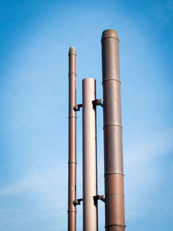 Series of three smokestacks in the skyの写真素材