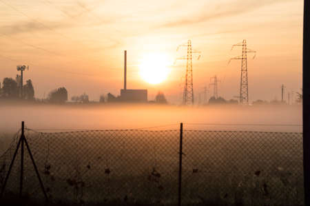 Suburban sunrise over the town, with pylons on backgroundの写真素材